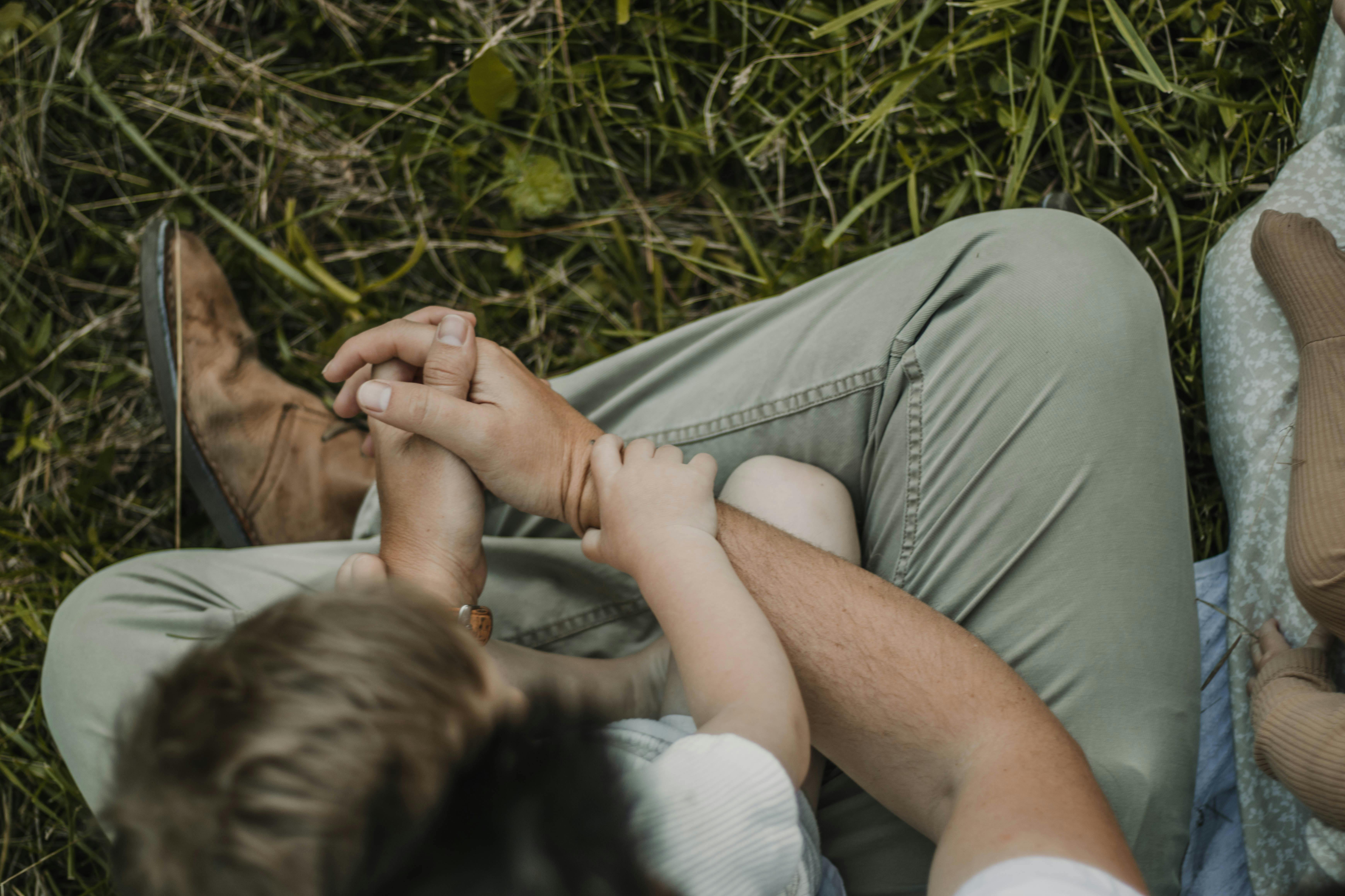 A heartwarming moment of family bonding captured outdoors in a serene summer setting.